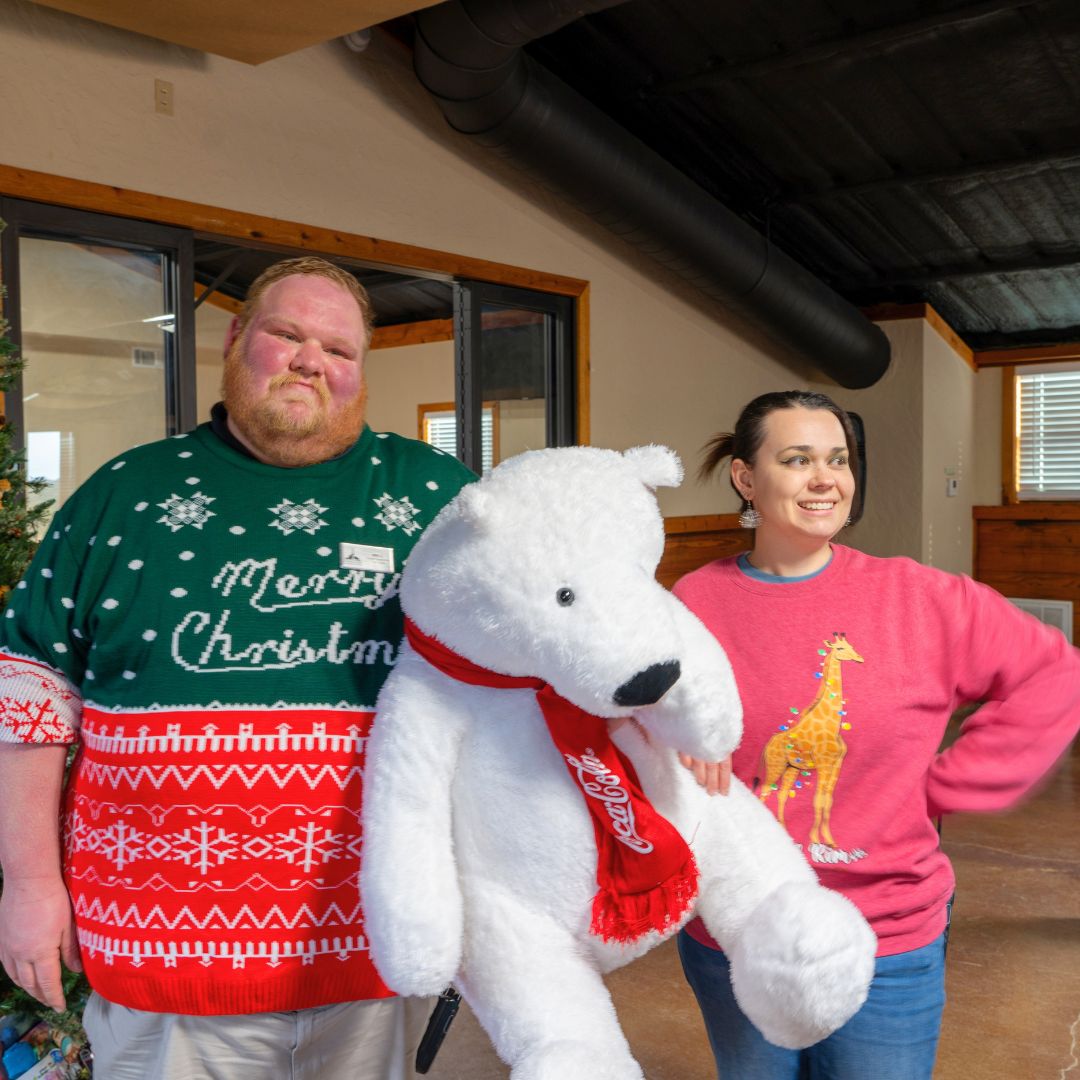 Will and Valerie Fossil Rim employees posing with the Coca-Cola polar bear.